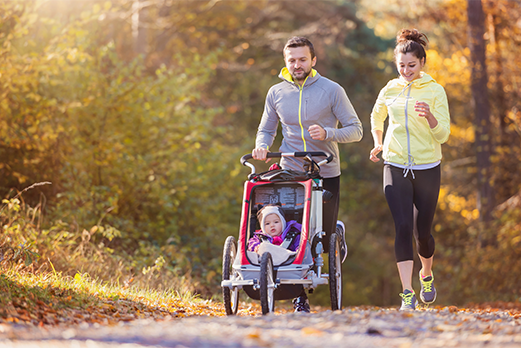 1643-7HealthAndWellness-521x348 Man and woman running with child in stroller