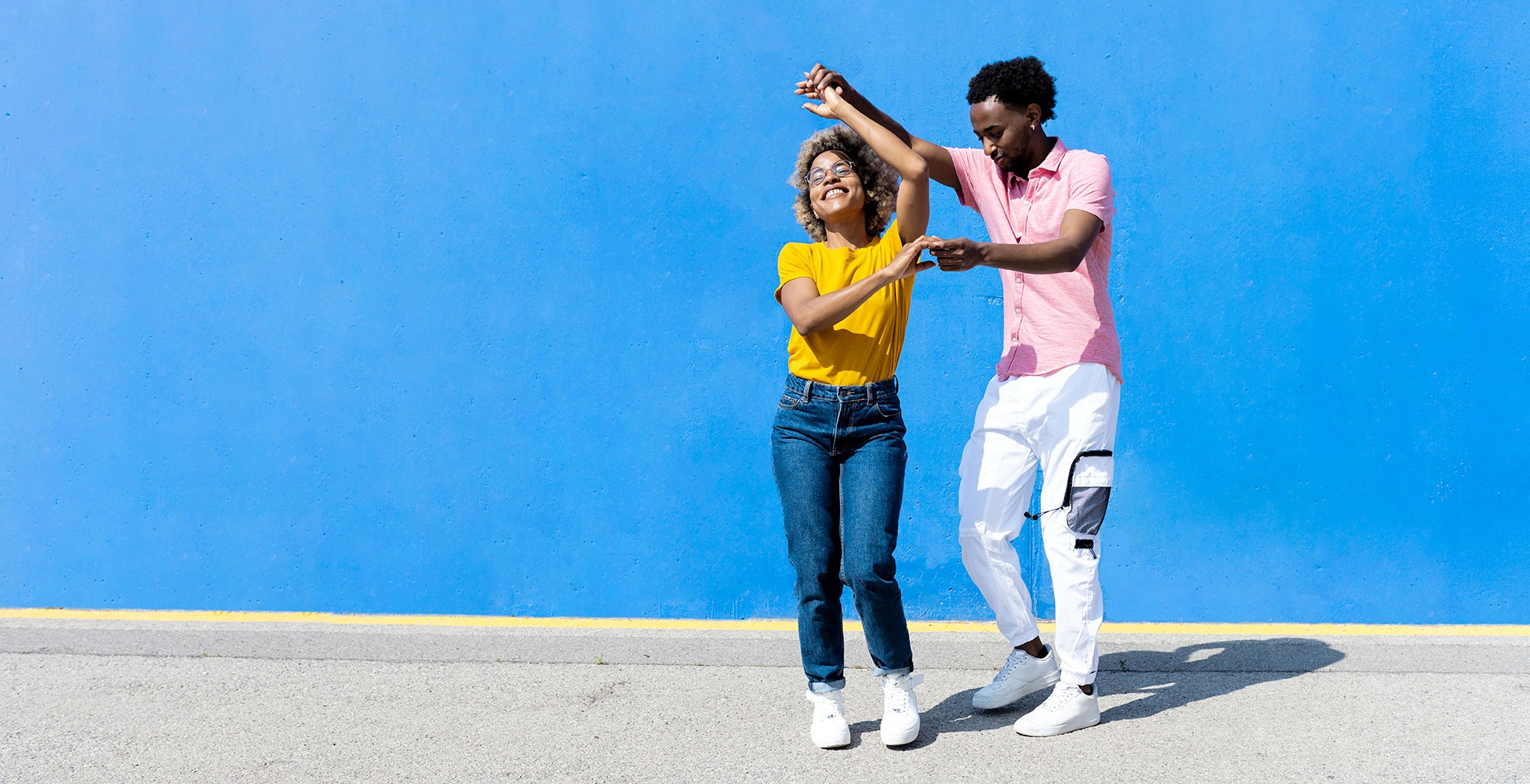 a young couple dancing in the street with a blue background