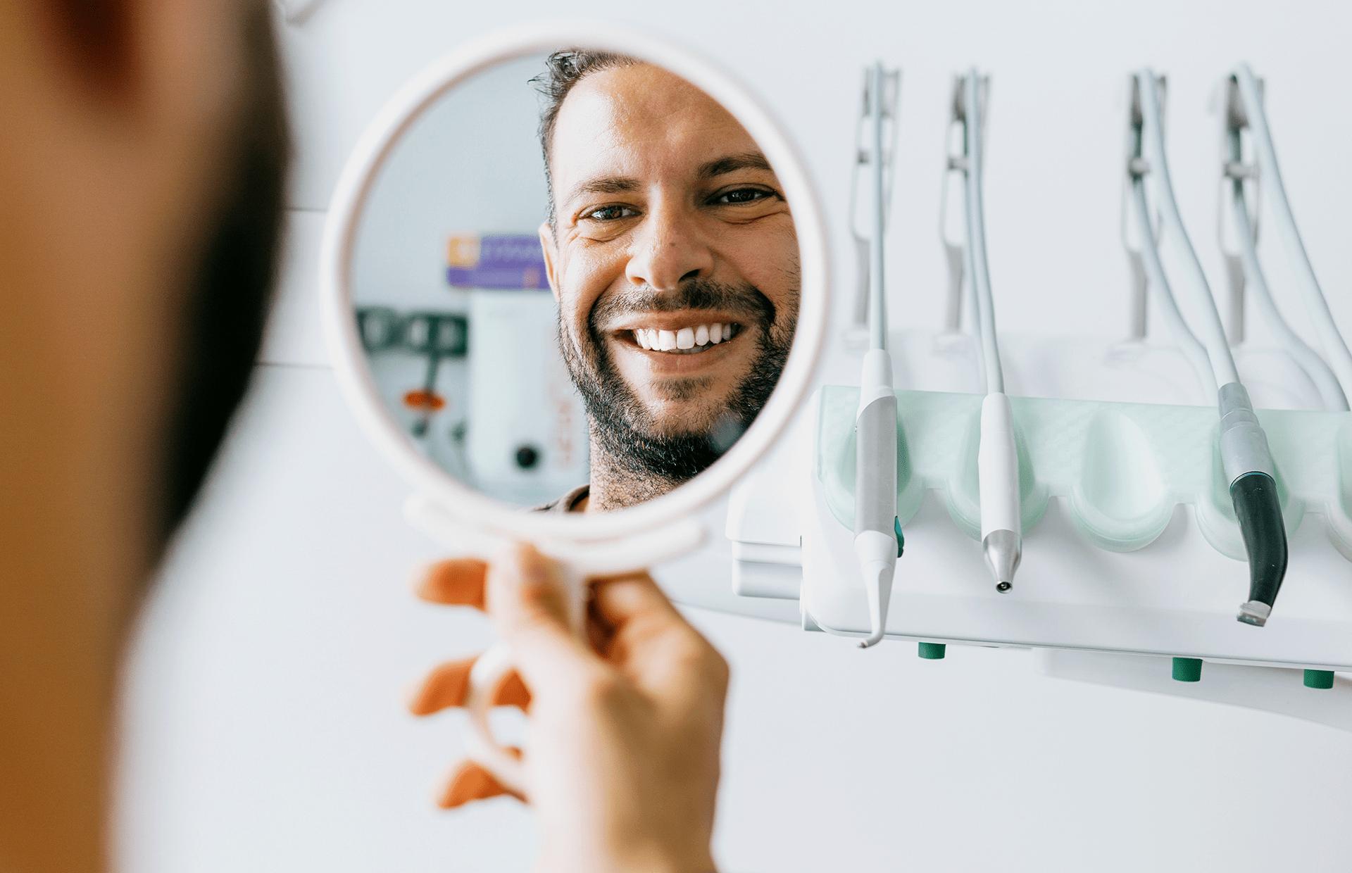 man smiling at reflection in mirror